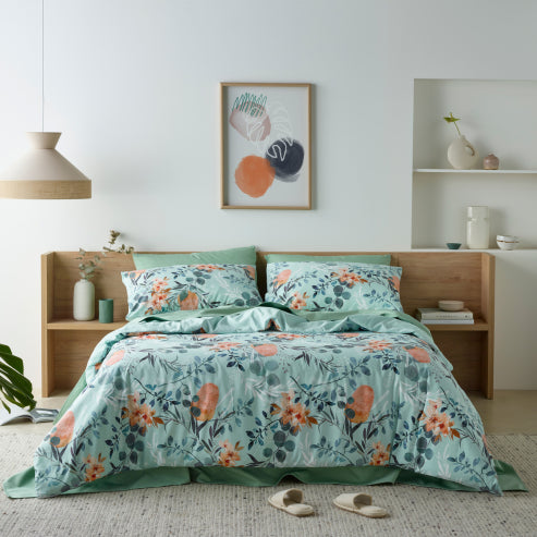 Bedroom featuring a luxurious water-resistant quilt cover set with a native Australian floral print in green and orange tones.