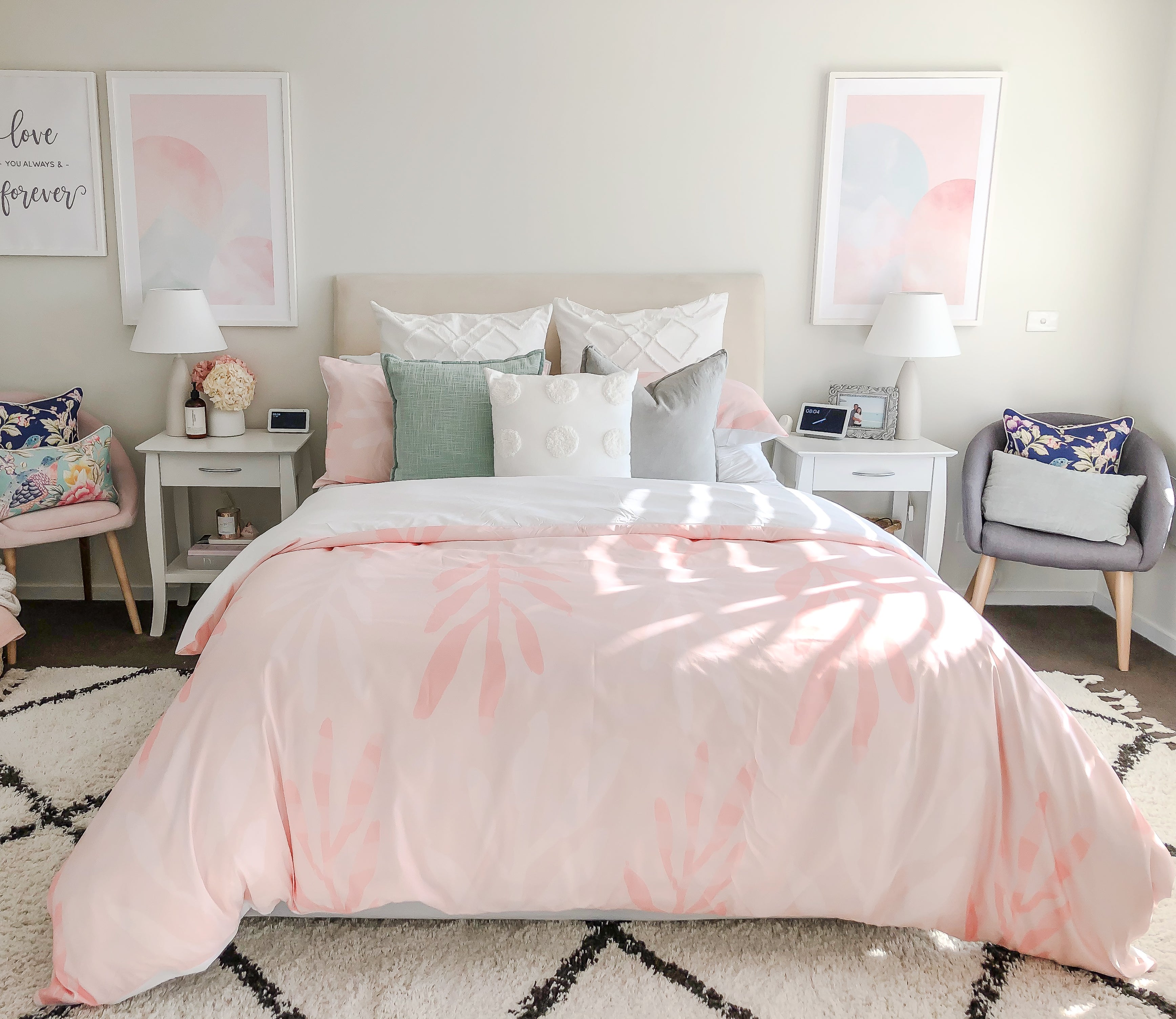 A light filled bedroom with the Botanica quilt cover in Peach on a queen sized bed.  There are complimenting display pillows in mix of soft pastel colours.  