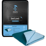 Teal colour bed pad sitting next to its packaging