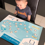 Little boy smiling at his toilet training chart.